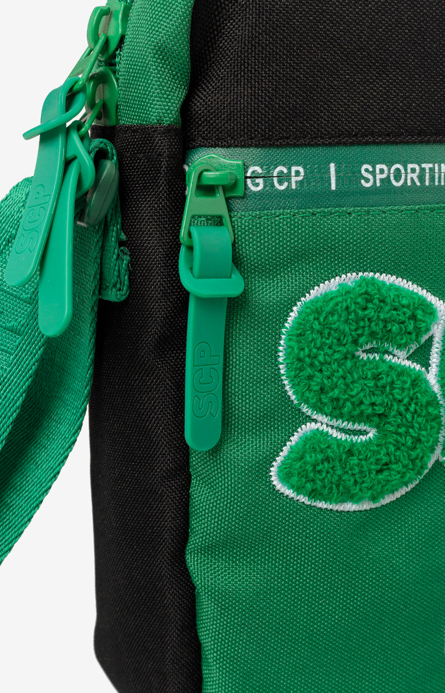 Pormenor lateral da Bolsa Tiracolo Escolar do Sporting, com fecho de correr.
