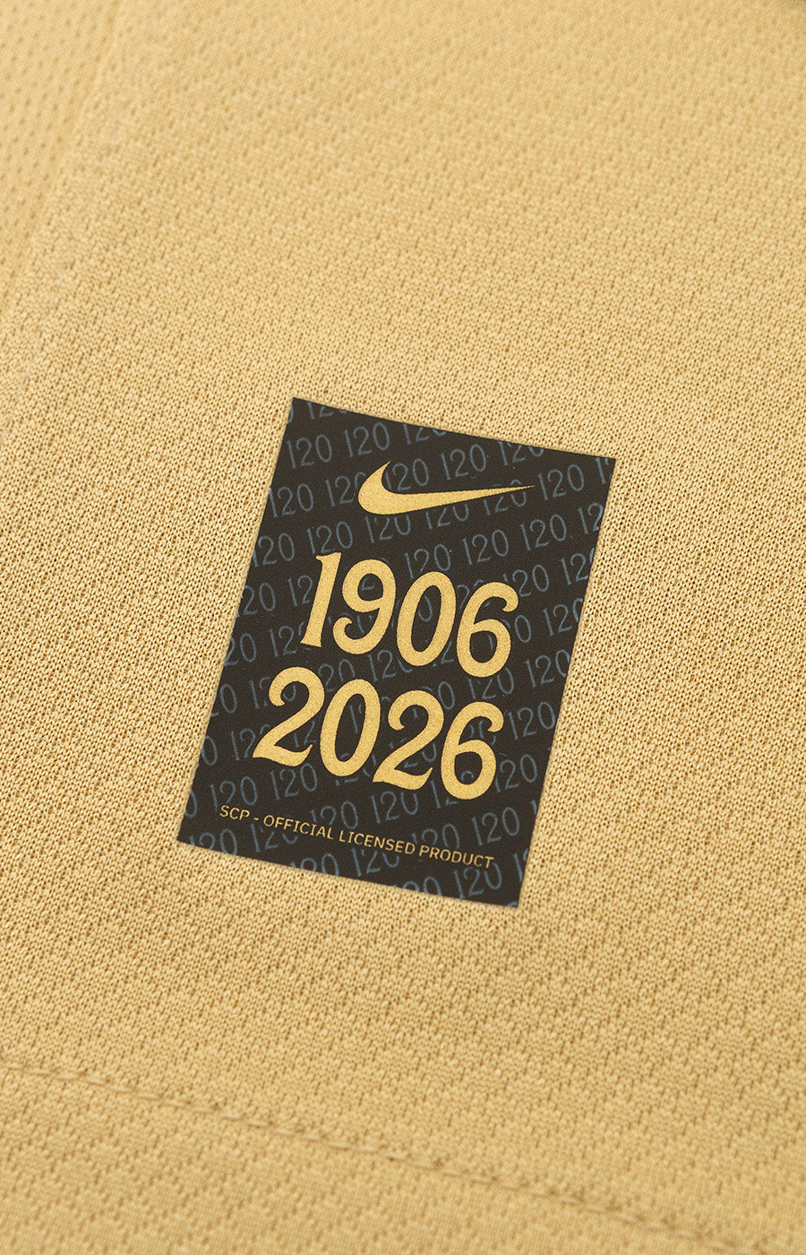 Commemorative 1906-2026 Nike label from the Sporting Kids' 26/27 Gold Alternate Jersey.