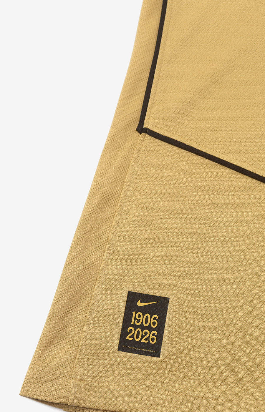 Étiquette Nike commémorative 1906-2026 sur l'ourlet du maillot alternatif Total 90 du Sporting 26/27.
