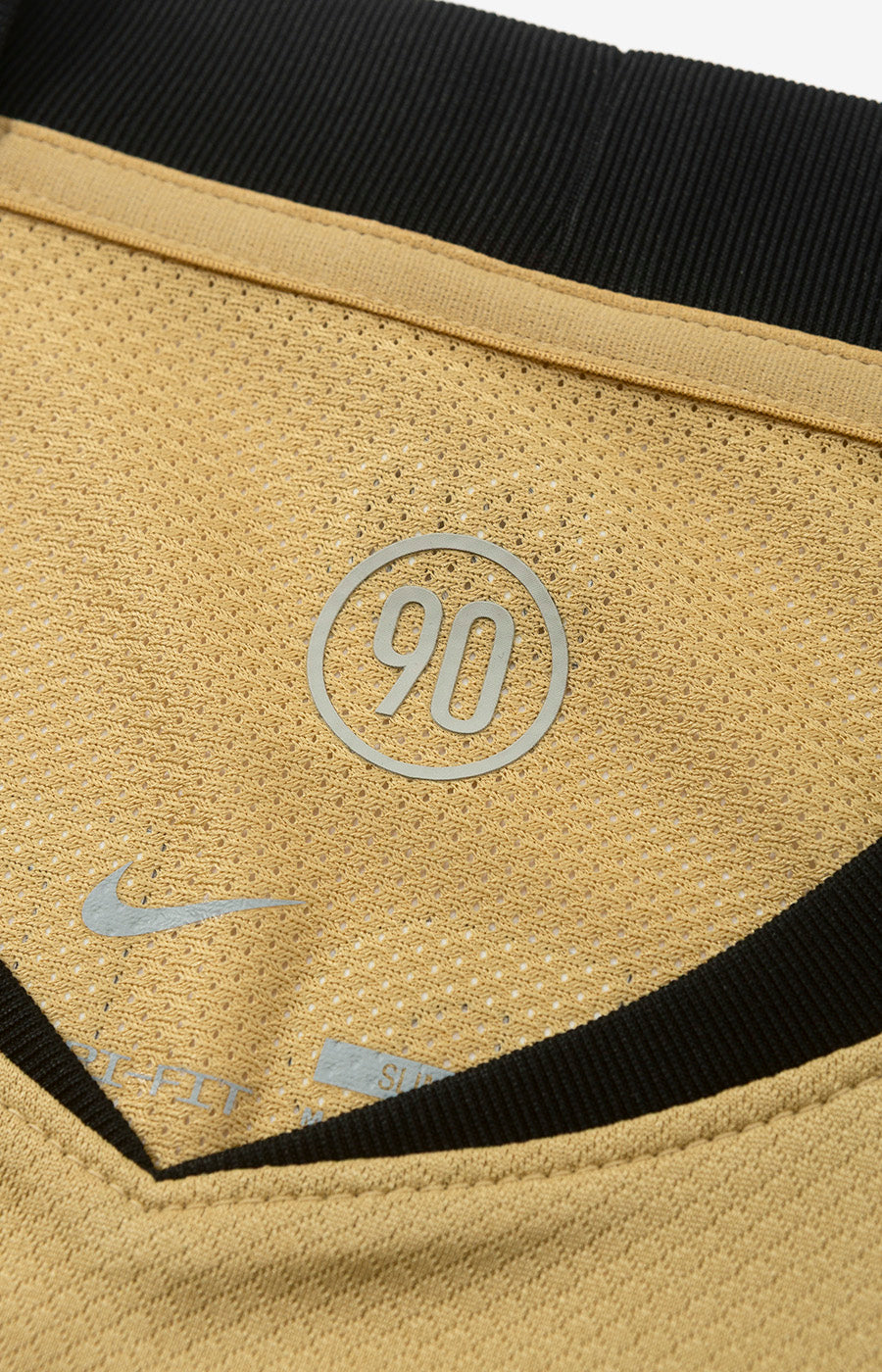 Logo « Total 90 » et swoosh Nike à l'intérieur du col du maillot alternatif doré du Sporting 26/27.