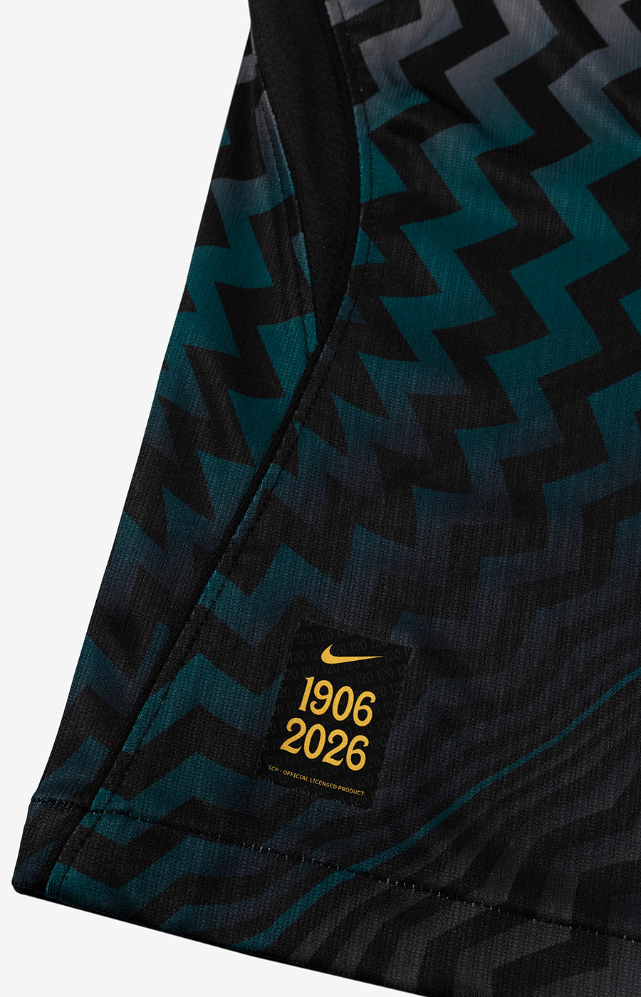 Detalhe da etiqueta dourada e do acabamento inferior da Camisola Guarda-Redes Preta do Sporting 26/27.