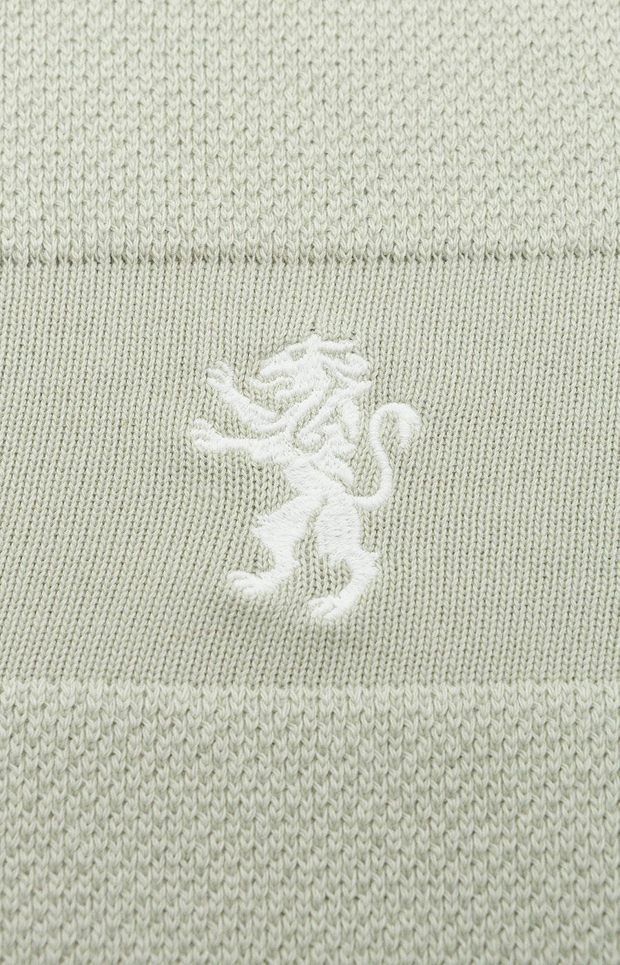 Pormenor do leão do Sporting bordado a branco na Camisola Textura Kakhi Leão.