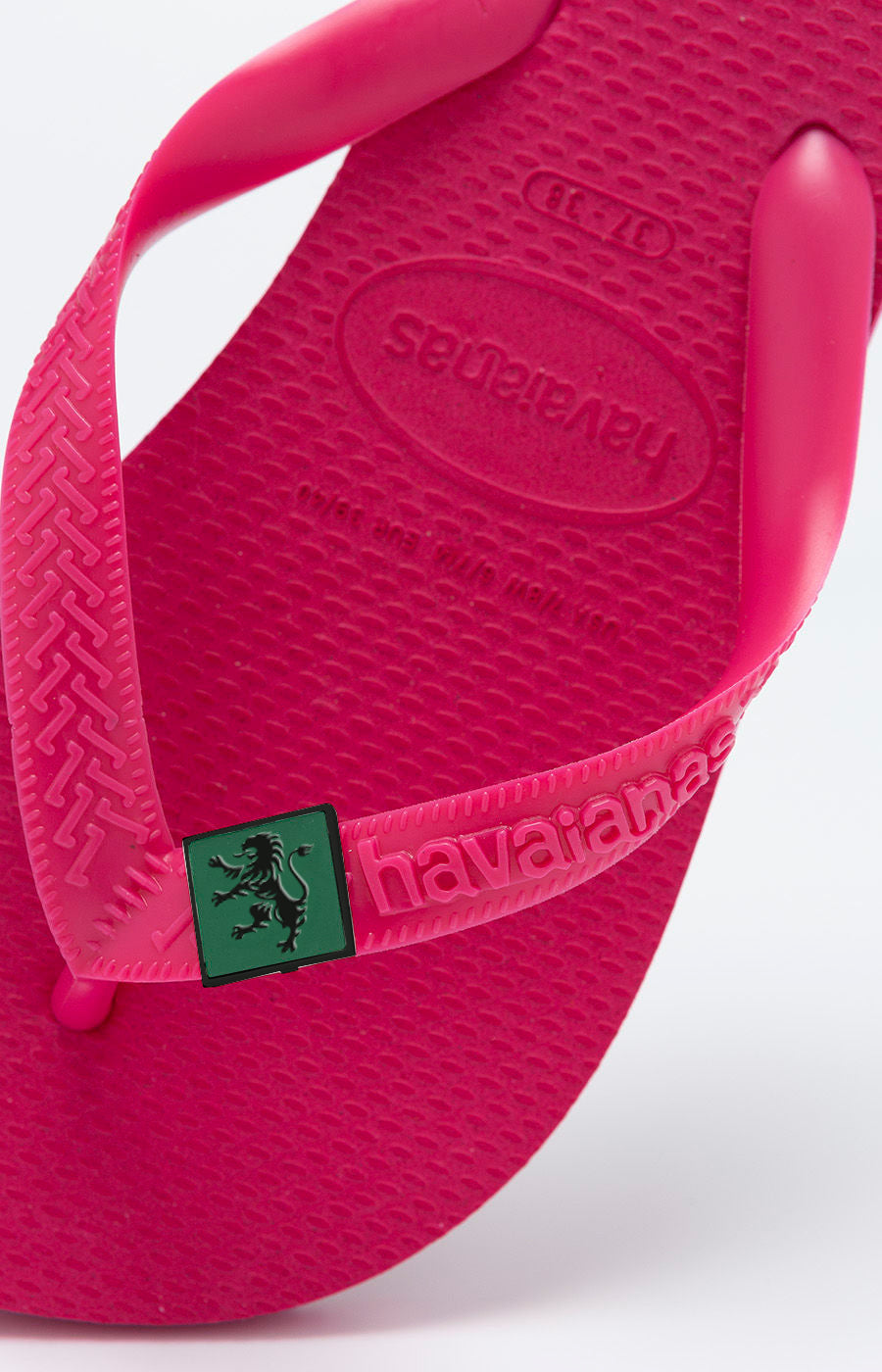 Pormenor da tira com pin do leão das Havaianas Cor de Rosa Leão do Sporting.