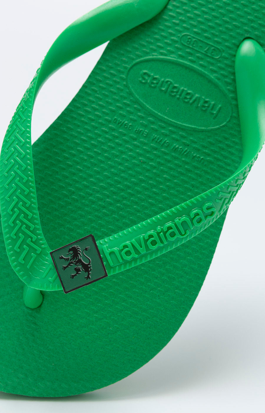 Havaianas Verde Claro Leão do Sporting, vista lateral com pin do leão na tira.