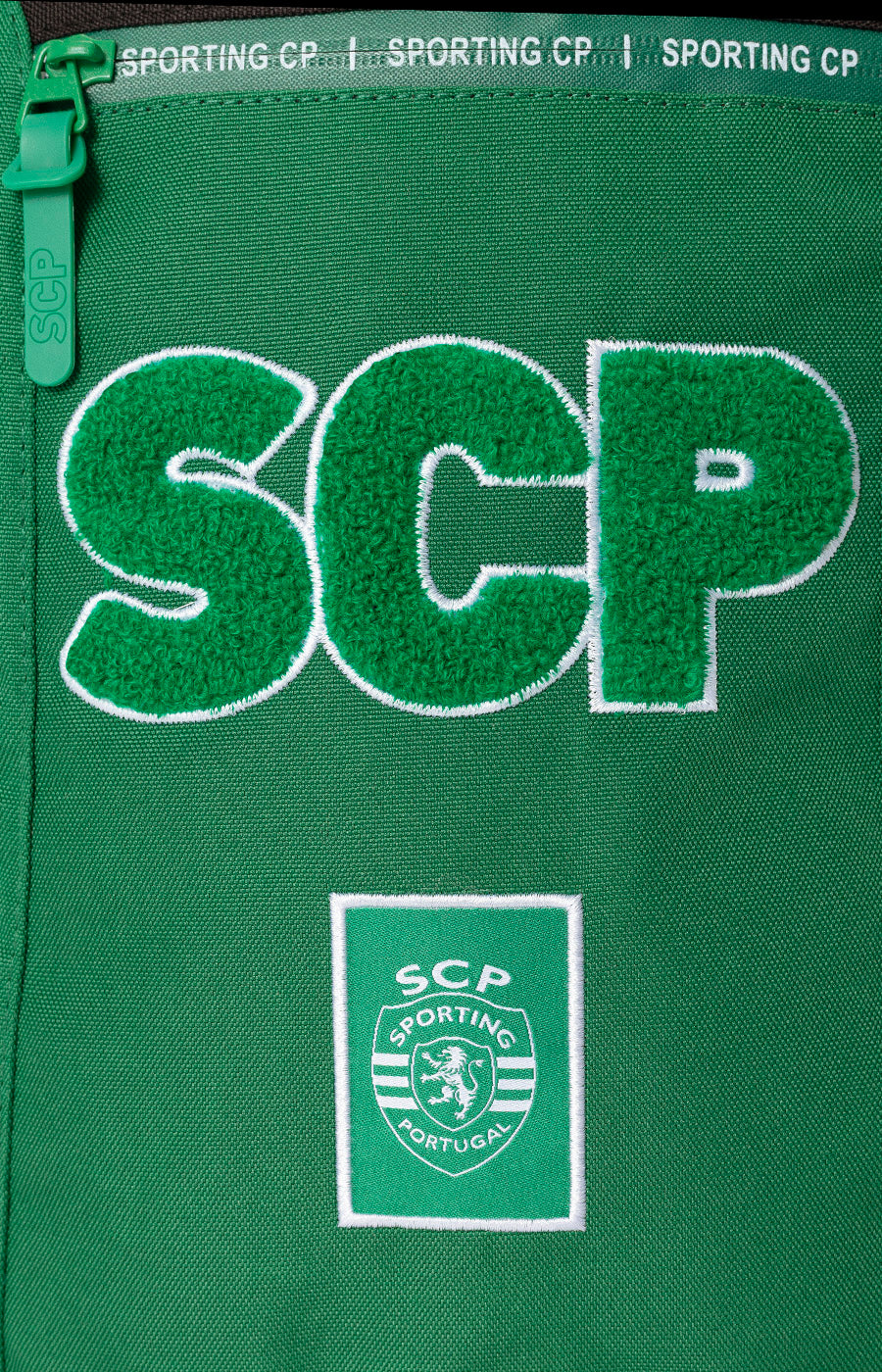 Letras SCP e emblema do clube aplicados na frente da Mochila Escolar do Sporting.