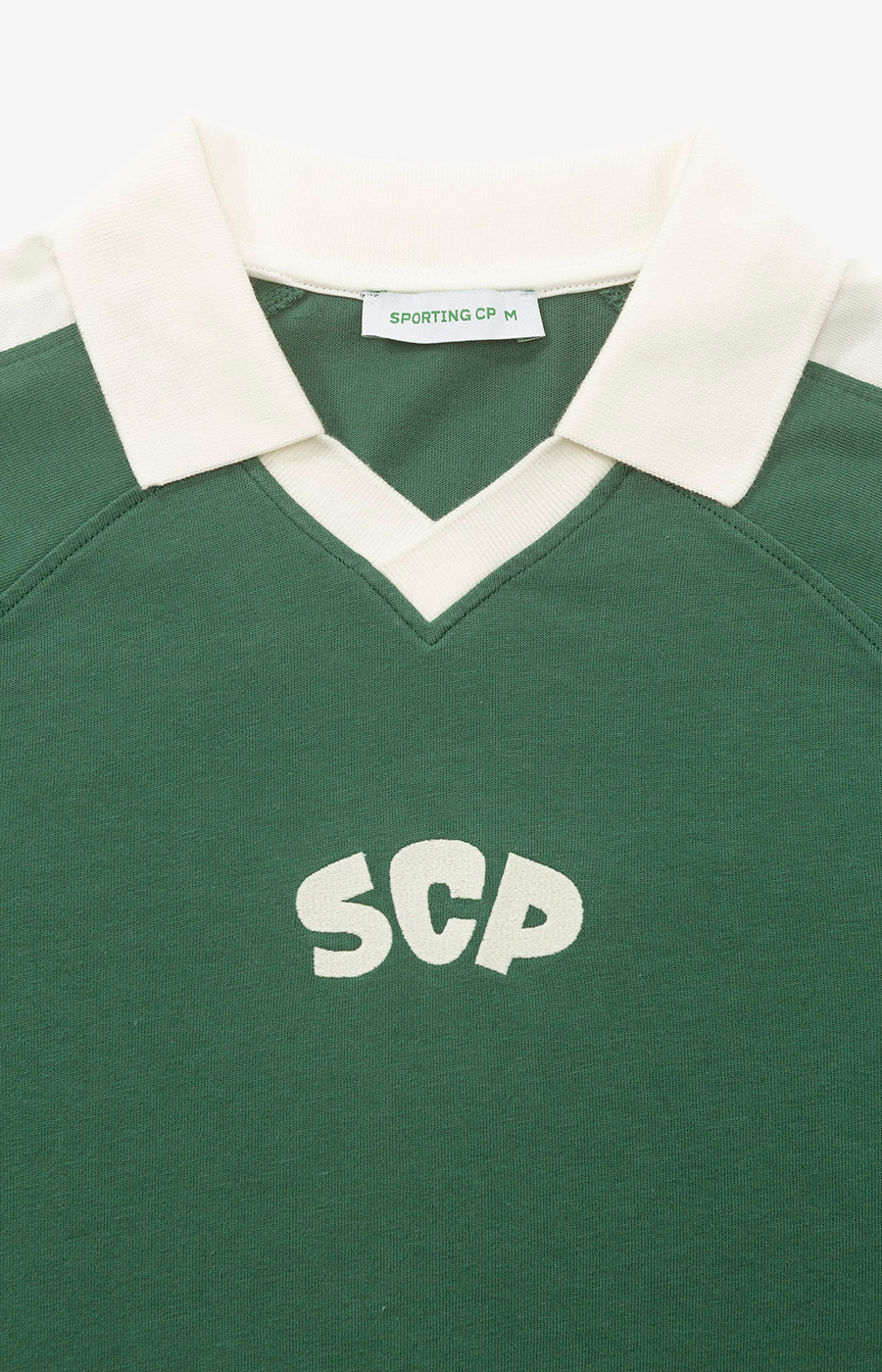 Pormenor da gola branca e do SCP ao peito do Polo Manga Comprida Verde Escuro do Sporting.