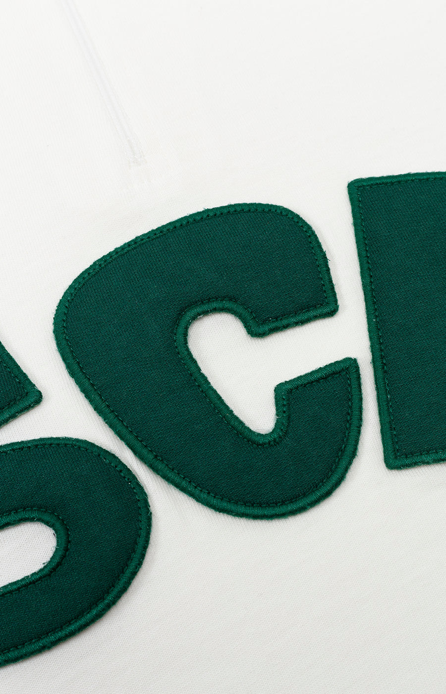 Detalhe das letras SCP em verde na frente do Polo Zip Branco Retro de mulher do Sporting.