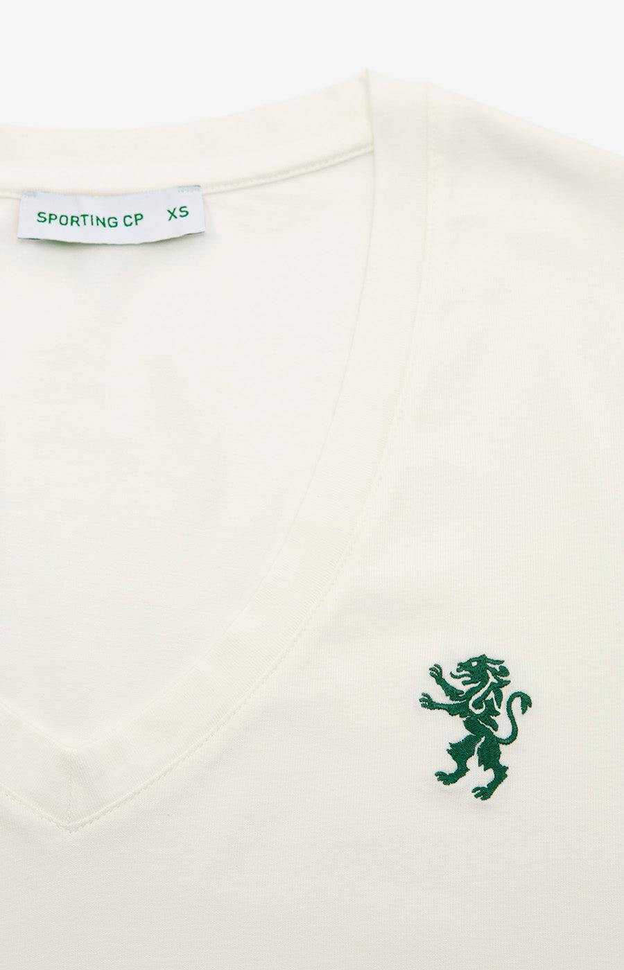 Detalle del león verde bordado en la camiseta blanca «Leão» de mujer del Sporting.