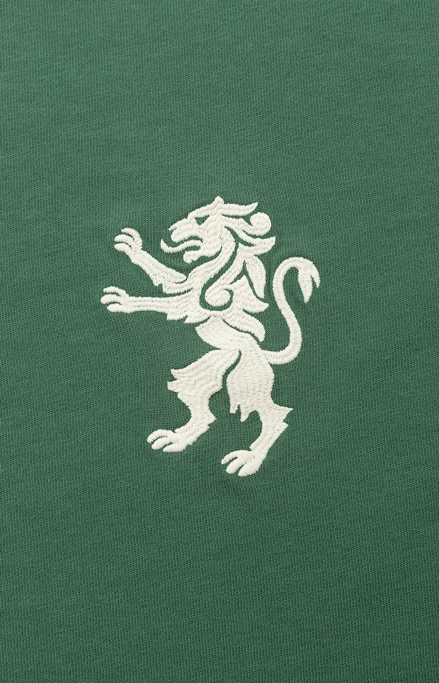 Pormenor do leão bordado a branco ao peito da T-shirt Verde Leão Sporting.